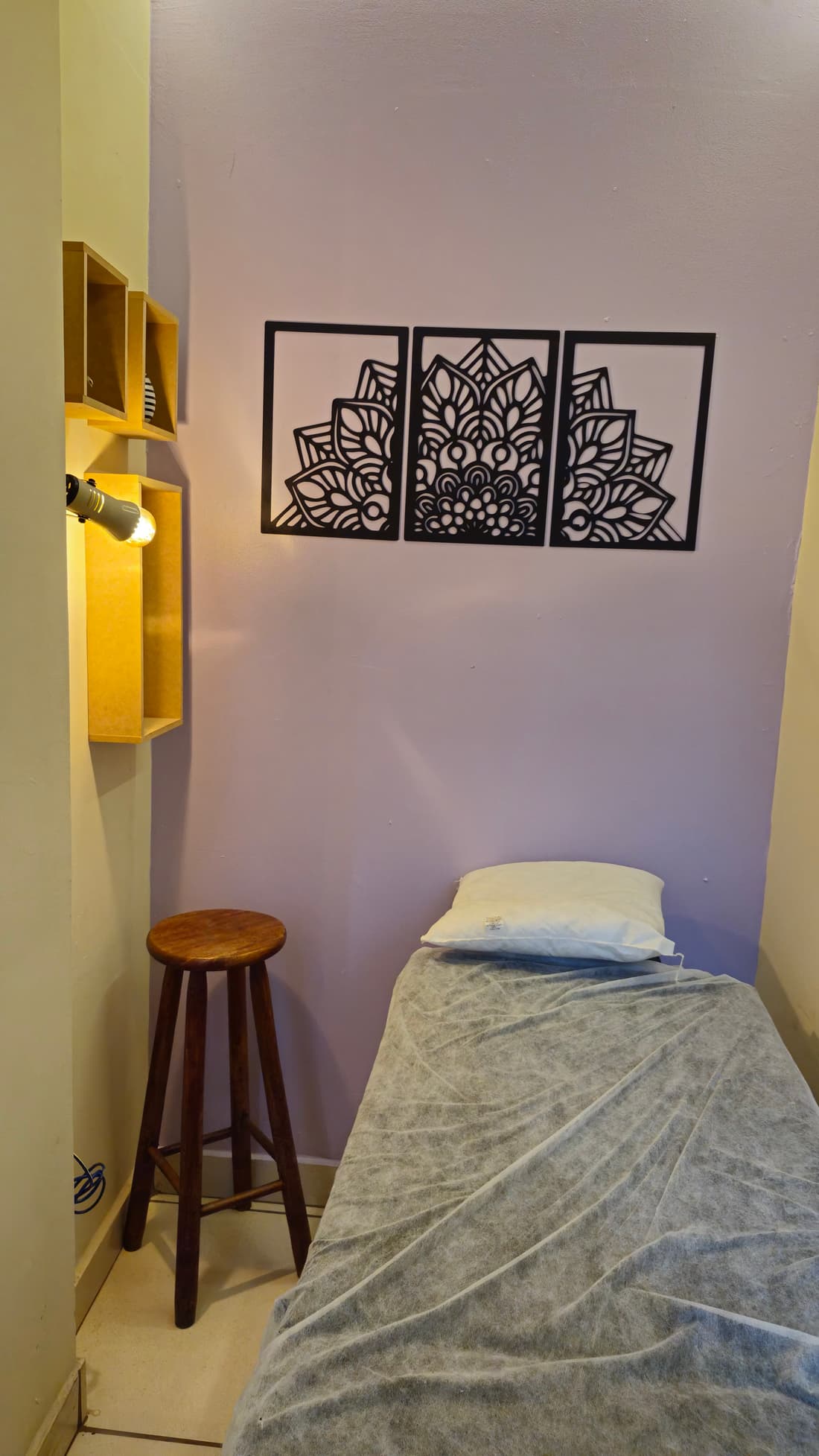 Detalhe da sala de terapias — maca, mandalas e luz indireta no Yoga du Ville