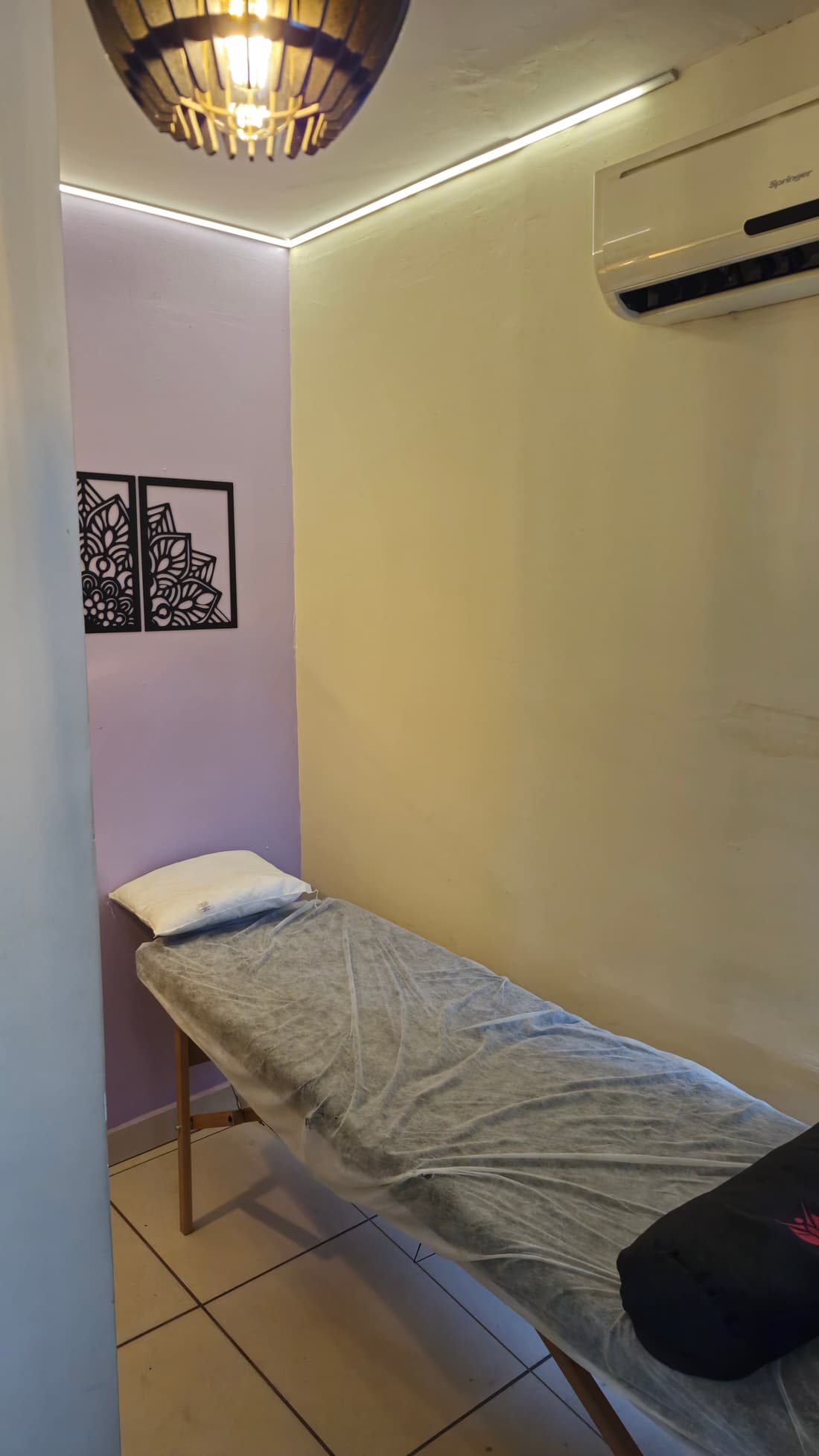 Maca de massagem na sala de terapias do Yoga du Ville — parede lilás e mandalas