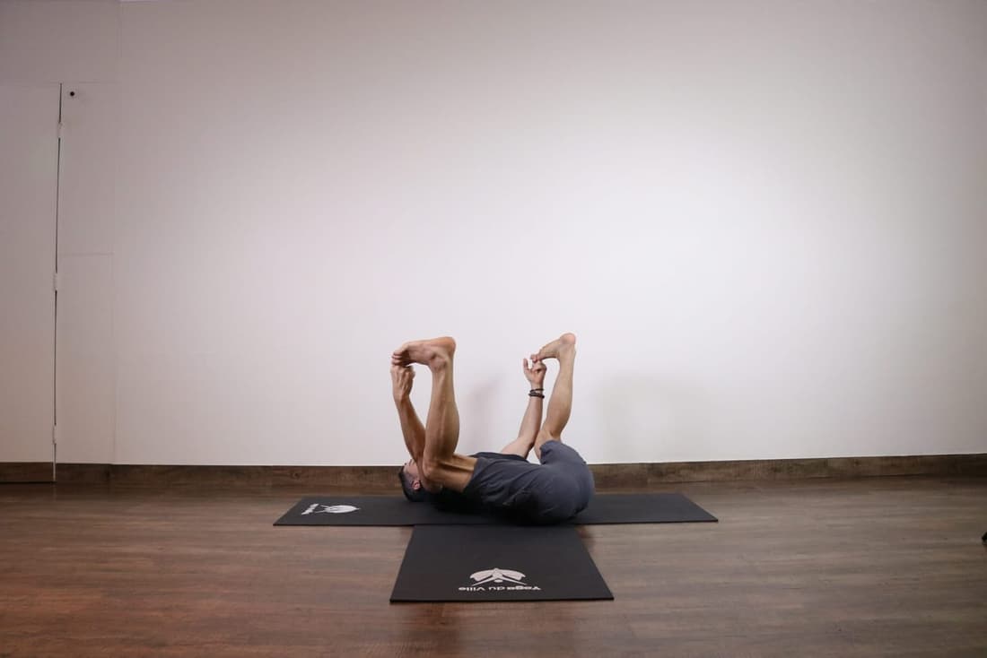 Professor Márcio executando a postura Ananda Balasana no Yoga du Ville, estúdio localizado na Tijuca, zona norte do Rio de Janeiro.