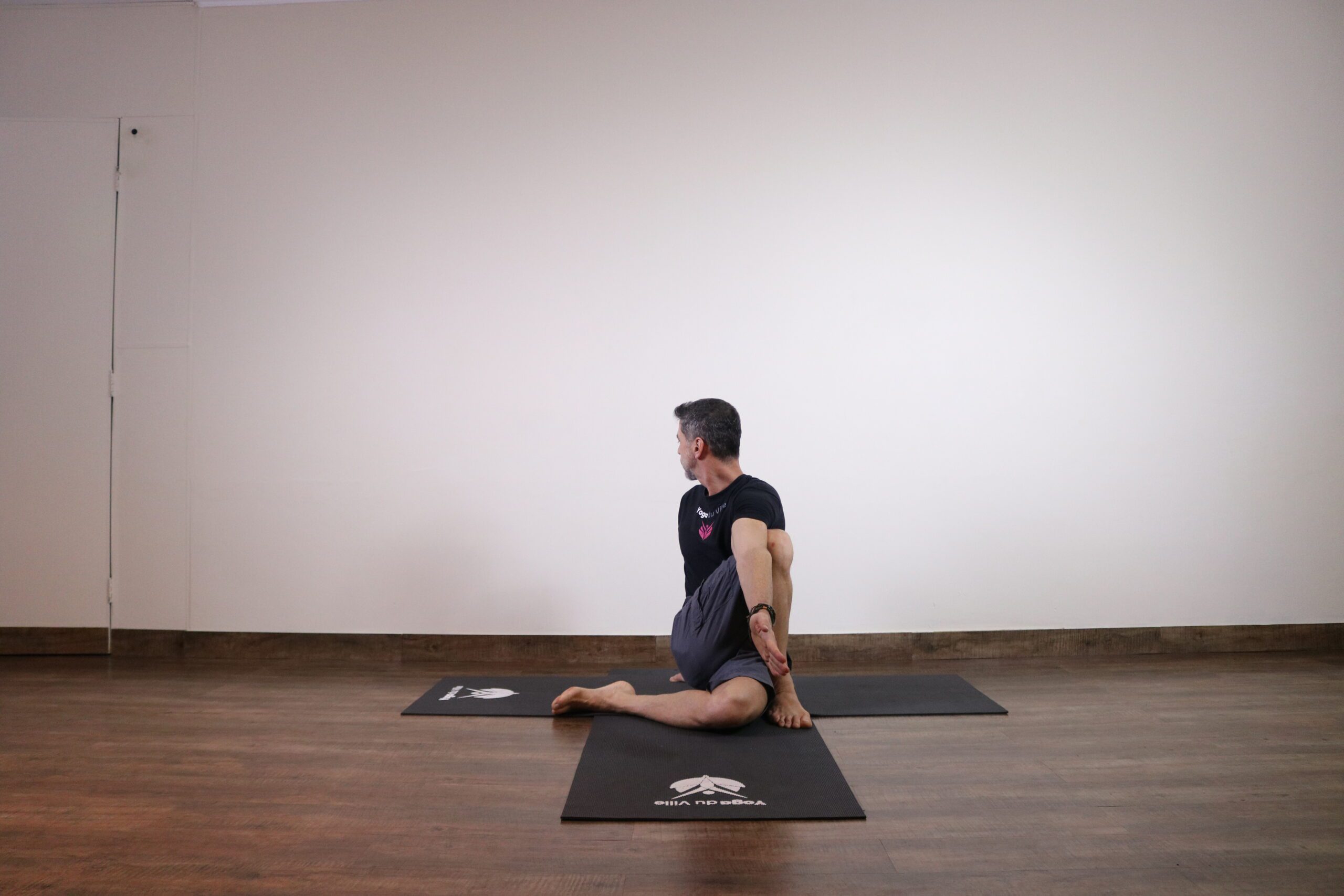 Instrutor Márcio demonstrando Matsyendrasana, postura do Senhor dos Peixes no yoga, em aula no estúdio Yoga du Ville, Tijuca, RJ