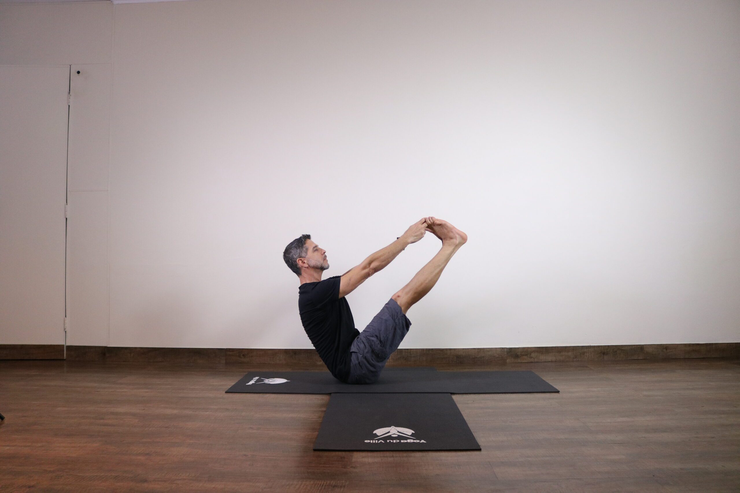 Professor Márcio demonstrando a Naukasana, postura do barco, durante aula no Yoga du Ville na Tijuca – Rio de Janeiro.