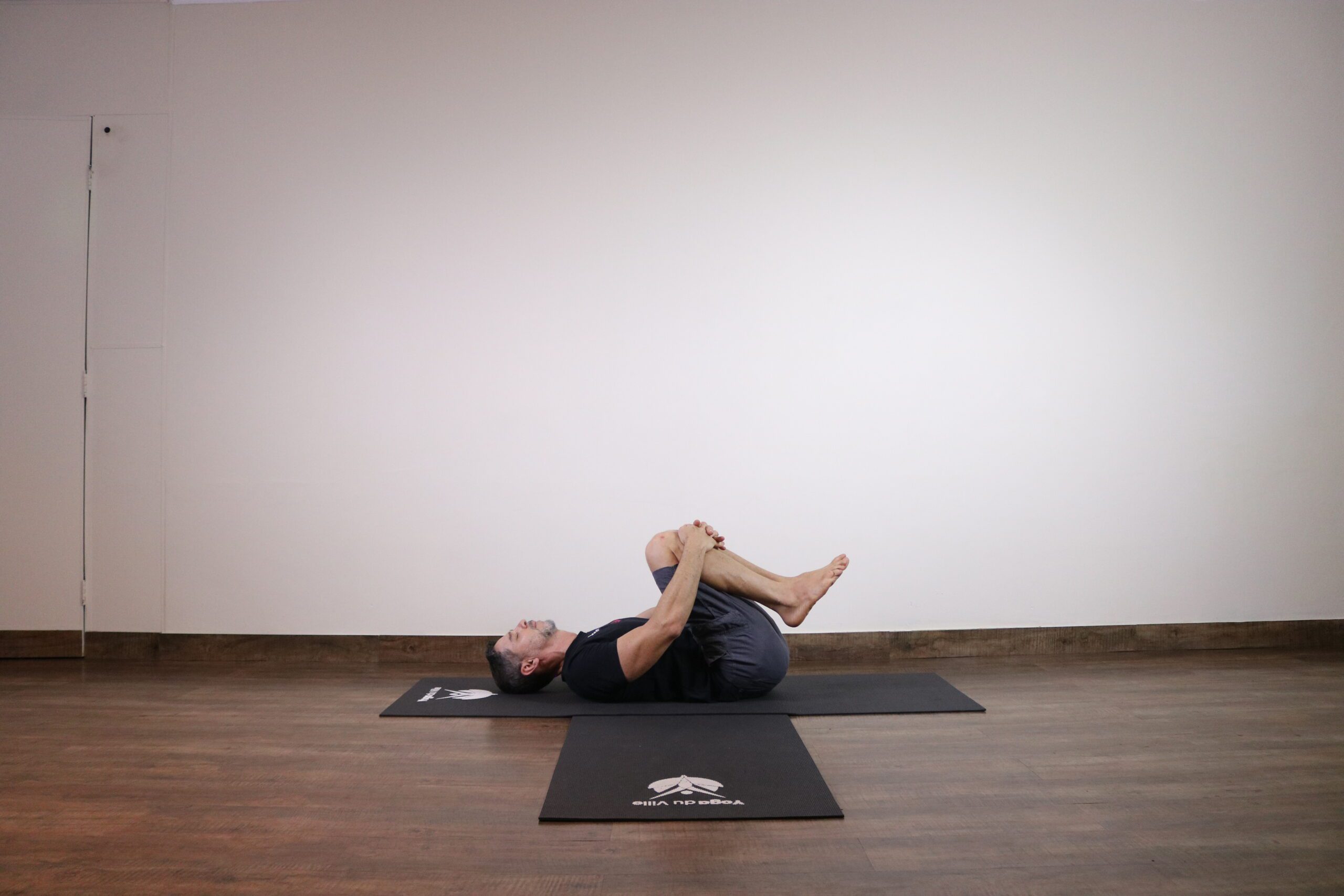 Professor Márcio demonstra a postura Pawan Muktasana no estúdio Yoga du Ville, Tijuca, Rio de Janeiro.