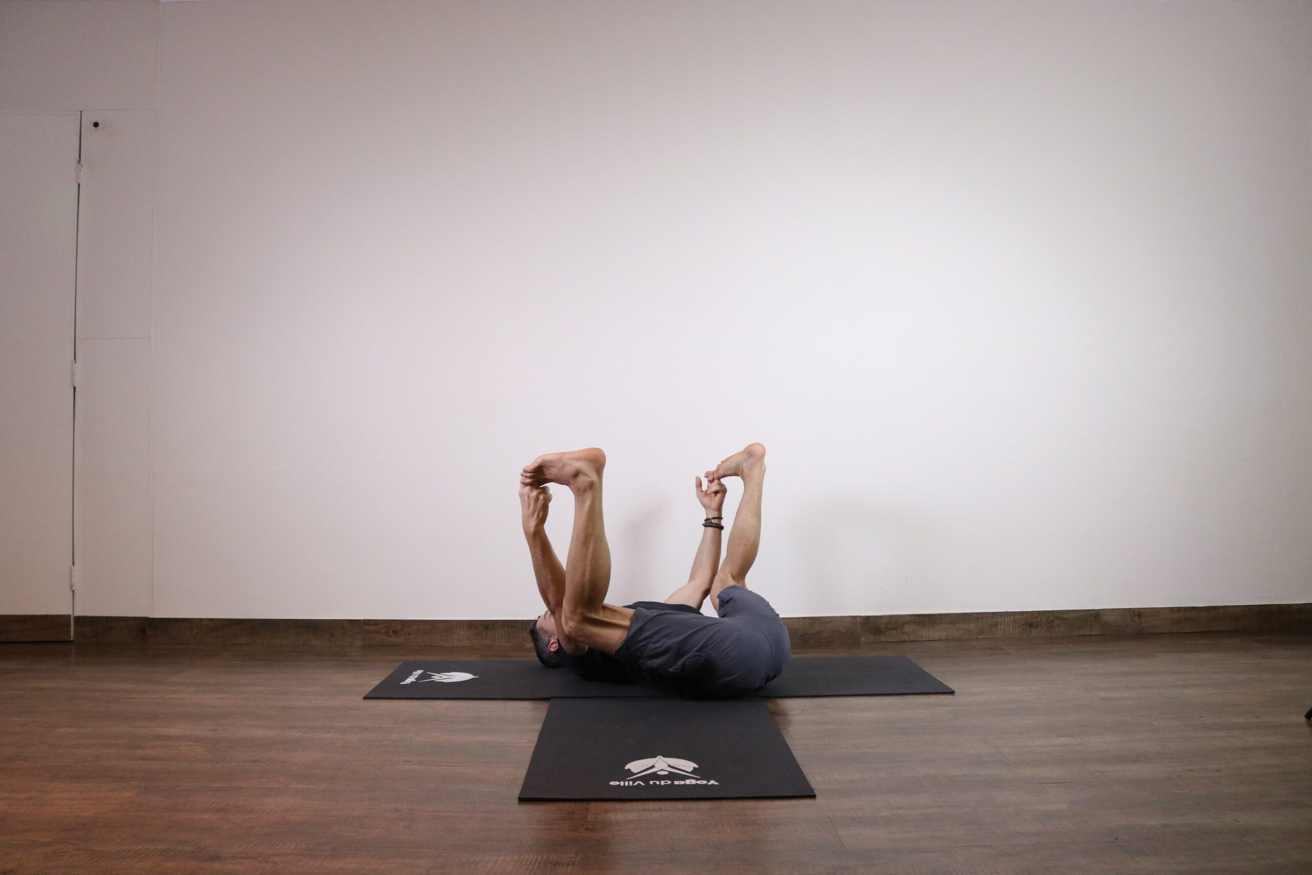 Professor Márcio executando a postura Ananda Balasana no Yoga du Ville, estúdio localizado na Tijuca, zona norte do Rio de Janeiro.