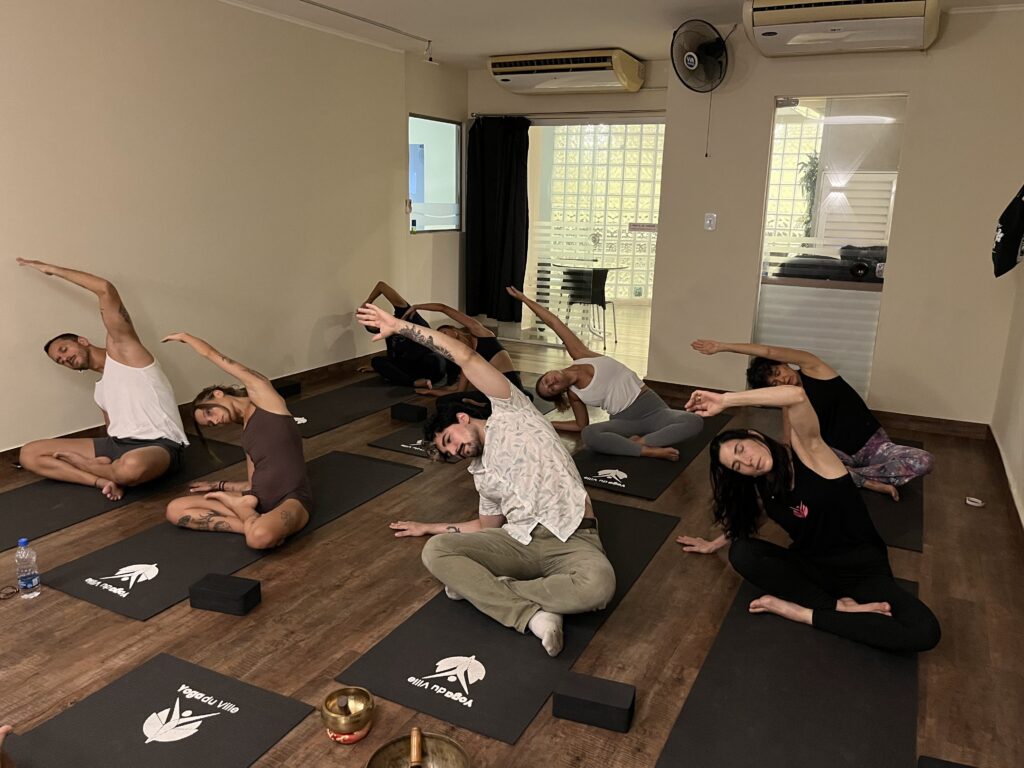 Grupo de alunos em aula de yoga no studio Yoga du Ville, localizado na Praça Saens Peña, Tijuca.